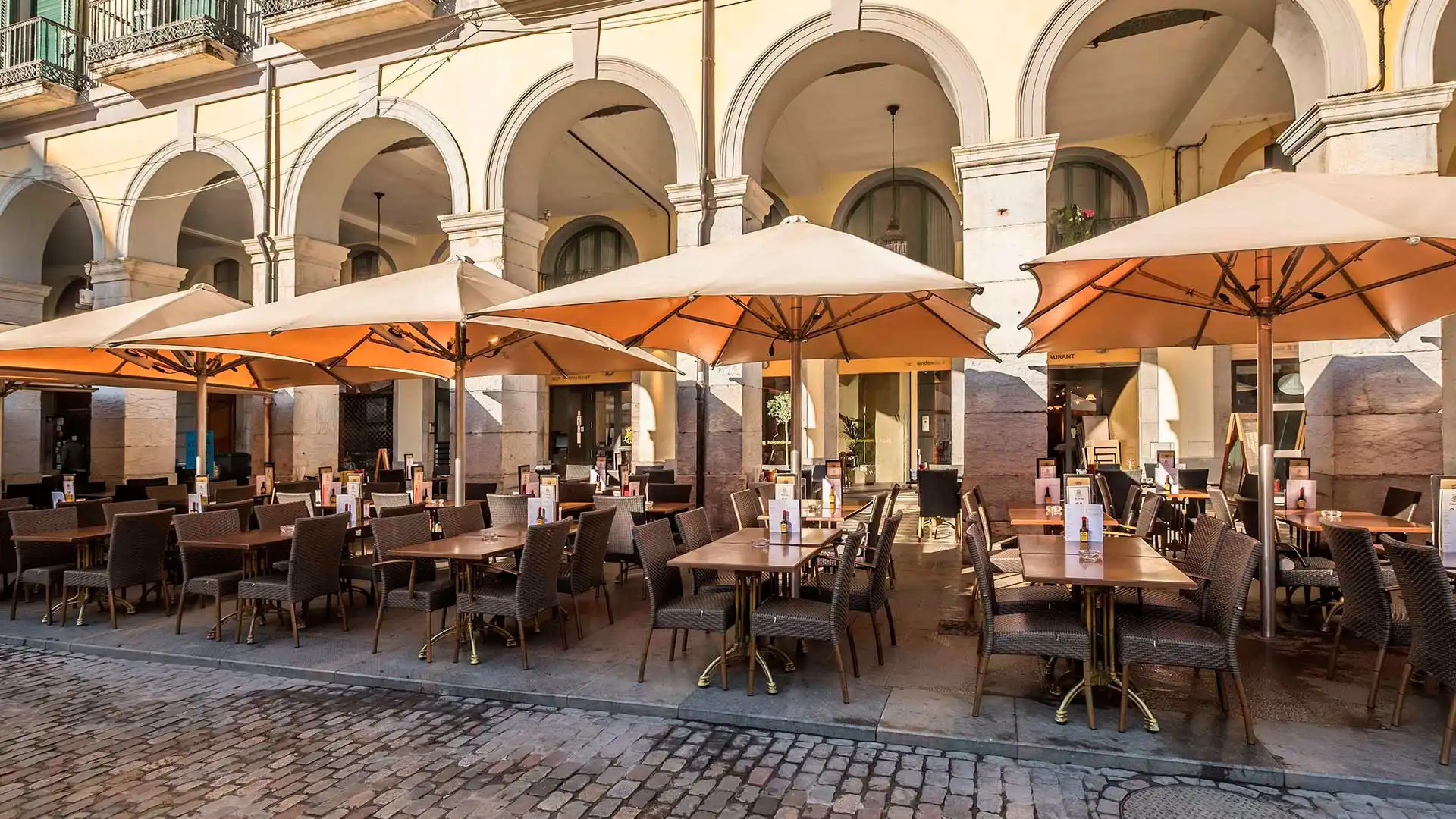 Terraza de un bar con mesas bajo los arcos en Barcelona